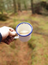 Midsection of man holding coffee cup