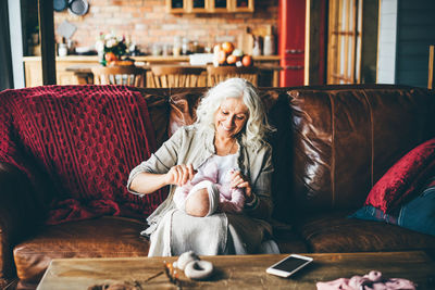 Portrait of woman sitting on sofa at home