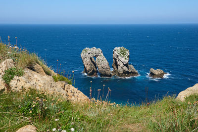 Whimsical rock formations with a turquoise blue sea and a beautiful blue sky.