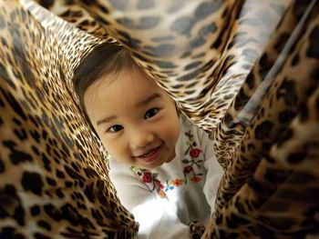 Close-up portrait of cute baby girl in blanket