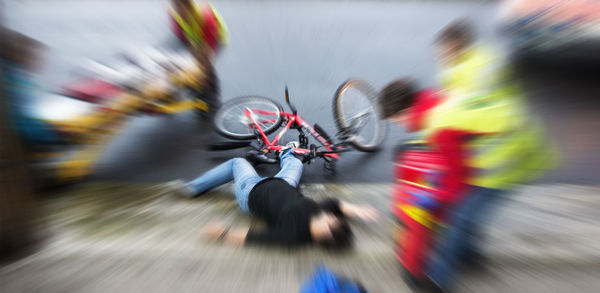 Blurred motion of people with bicycle on road