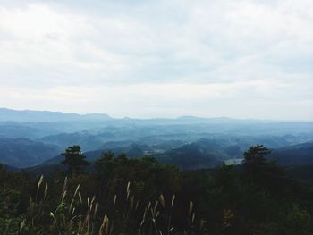 Scenic view of mountains against cloudy sky