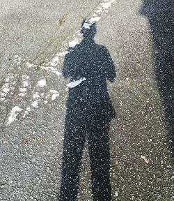 Shadow of person on road in city
