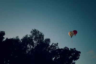 Low angle view of balloons against clear blue sky