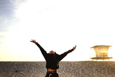 Silhouette of woman standing against sky