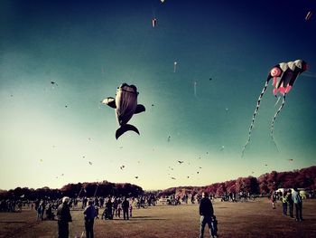 Group of people flying kite against sky