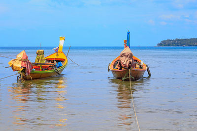 Boat moored on sea against sky