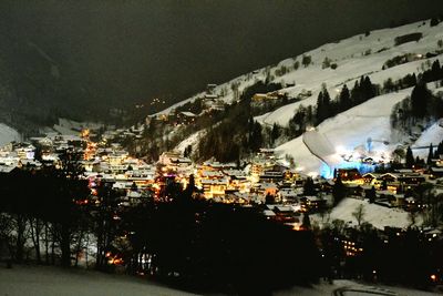 Illuminated cityscape against sky at night