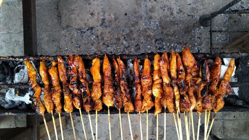 The process of grilling chicken satay using charcoal