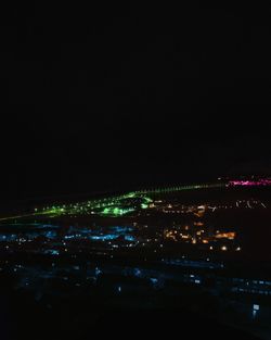 Aerial view of illuminated cityscape against sky at night