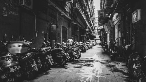 Motorcycles parked in alley amidst buildings in town