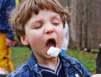 Close-up of boy eating ice cream on field