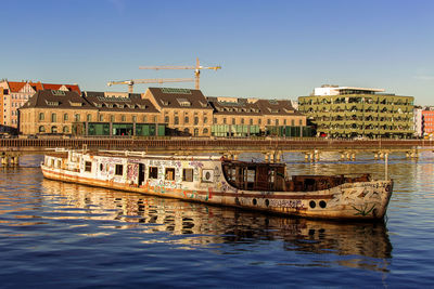 Boats moored on shore against clear sky