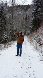 Full length of man walking on snow covered field