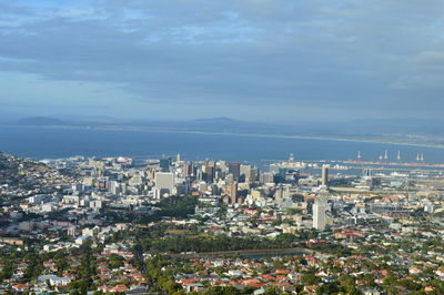 High angle view of city buildings against cloudy sky