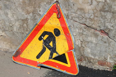 High angle view of broken men at work sign against wall