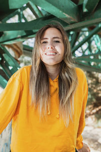 Portrait of young woman sitting on railway bridge