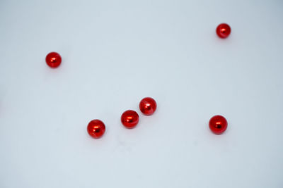 Close-up of red berries over white background