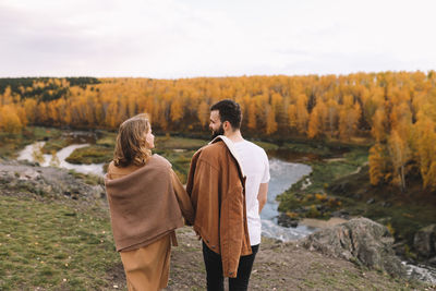 Rear view of couple standing on land