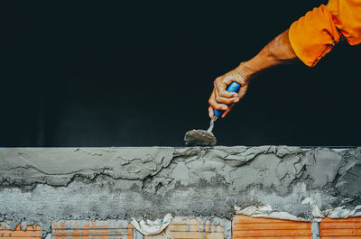 Cropped hand of man building retaining wall