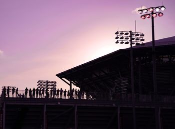 Low angle view of silhouette people against sky at sunset