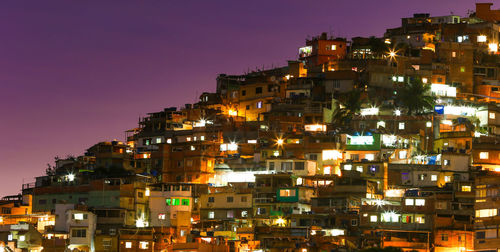 Illuminated cityscape against clear sky at night