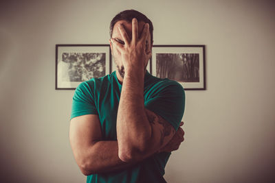 Photograph of a man with his hand in front of his face