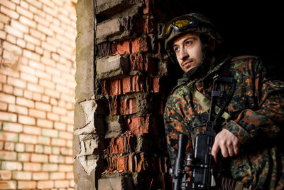 Portrait of man standing against wall