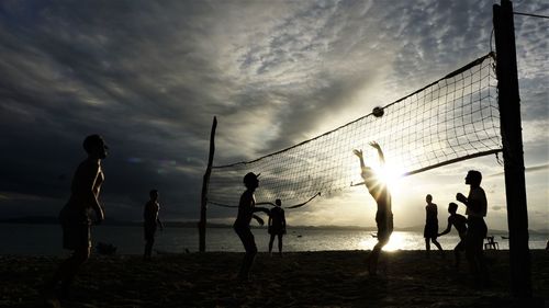 People playing with volleyball at beach