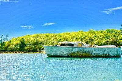 Boat moored by lake against sky