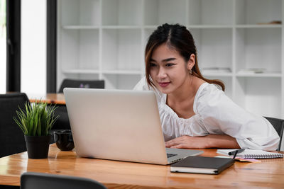 Businesswoman using laptop at table