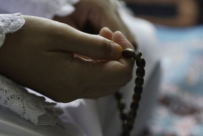 Close-up of woman hand holding cross