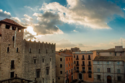 Buildings in city against cloudy sky