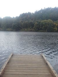 Jetty on pier over lake against sky