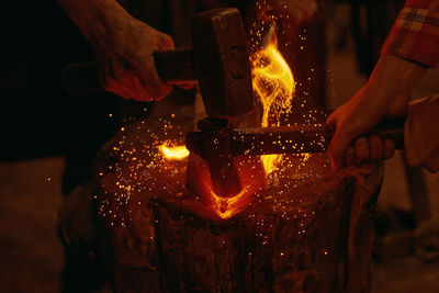 Midsection of man holding burning candles