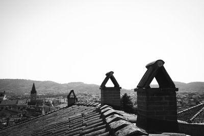 Man against built structure and mountain against clear sky