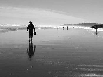 Man standing on beach against sky