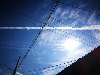 Low angle view of electricity pylon against blue sky