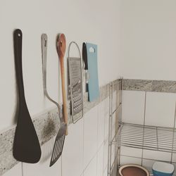 Kitchen utensils hanging on white wall