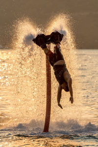 Man flyboarding in sea