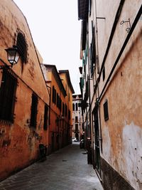 Narrow alley amidst buildings against sky