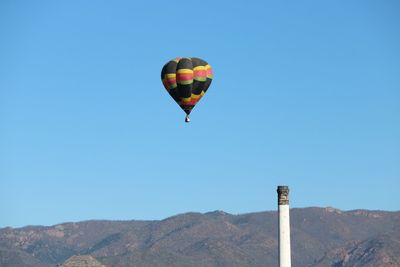 Hot air balloon flying against clear blue sky