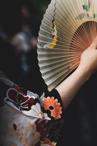 Midsection of woman holding hand fan