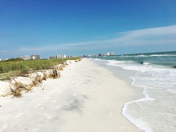 Scenic view of beach against blue sky