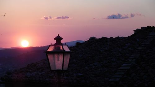 Low angle view of illuminated building against sky during sunset