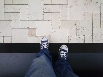 Low section of man standing on tiled floor