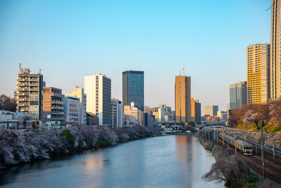 River amidst buildings against sky in city