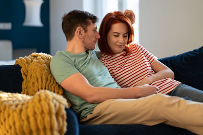 Portrait of smiling family sitting on sofa at home