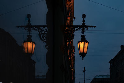 Low angle view of illuminated street light against building