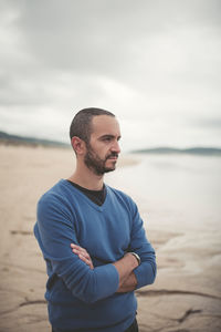 Close-up of man standing on beach against sky